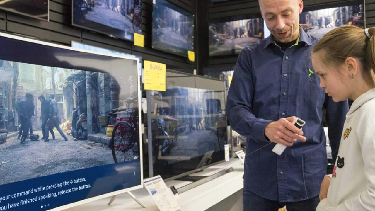 A young girl tests a voice-controlled TV in a store in Reykjavik