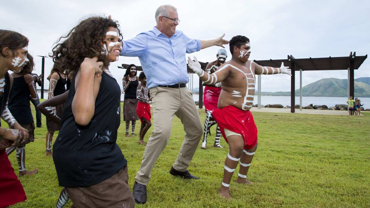 Prime Minister Scott Morrison dances with the Cooktown Dancers during a visit to Cooktown, Tuesday, January 22, 2019. Scott Morrison visited Cooktown to announce $5.5 million to support Cooktown's 2020 Festival. (AAP Image/Marc McCormack) NO ARCHIVING