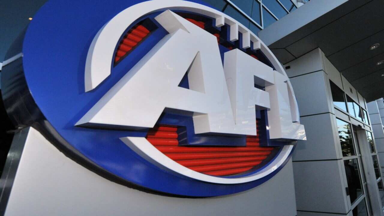 A man in a suit arrives at AFL House in Melbourne