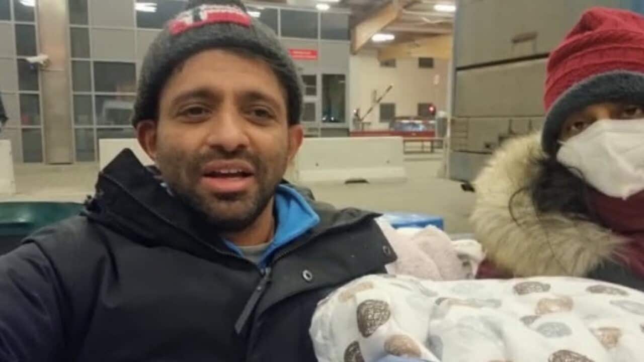 Ronak Raval (L) with a mother of two-months-old baby after crossing the Ukraine-Poland border.