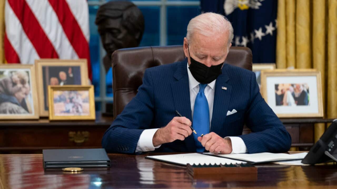 President Joe Biden signs an executive order on immigration in the Oval Office of the White House, Tuesday, 2 February, in Washington.