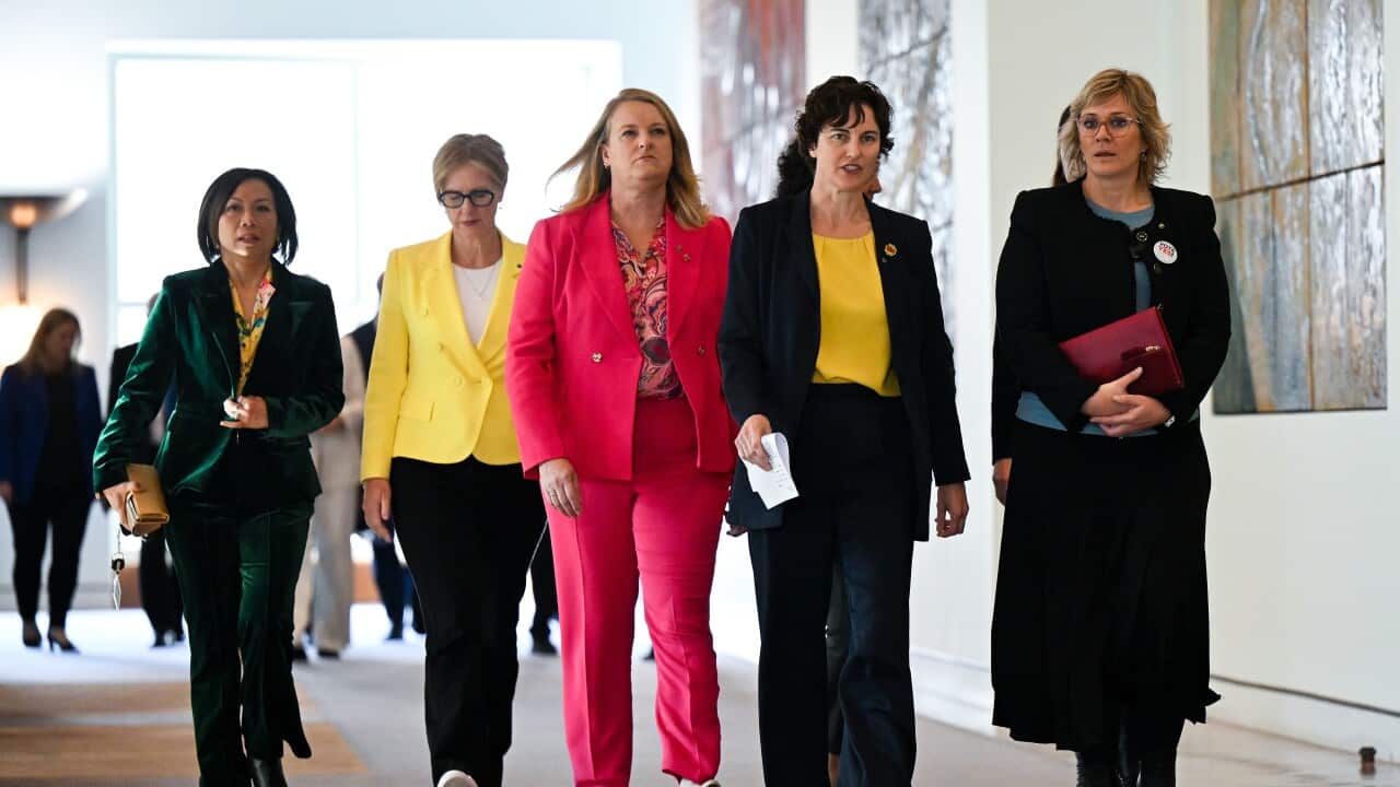 A group of women walking down a hall.