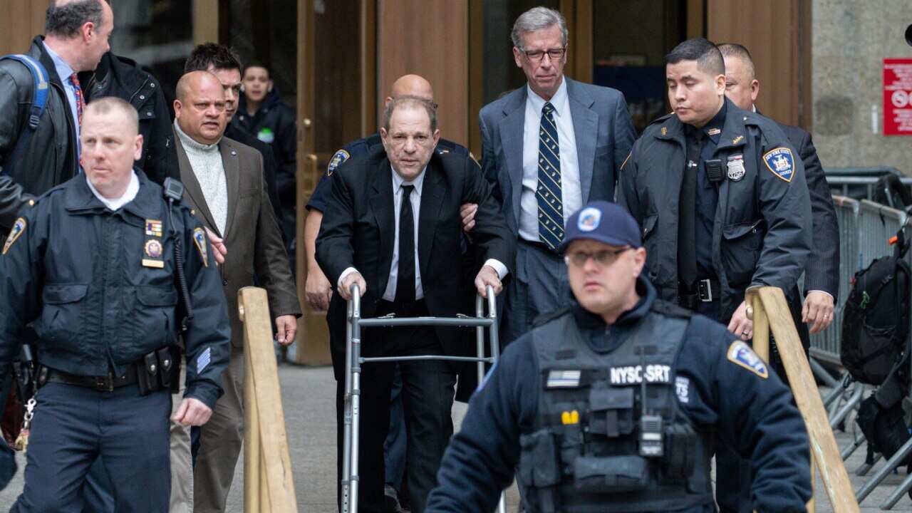 Harvey Weinstein (centre) surrounded by court officers