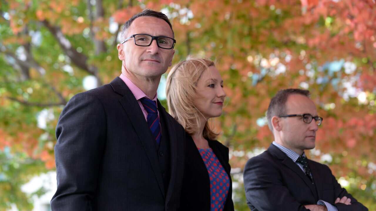 Outgoing Greens Leader Richard Di Natale stands alongside Senators Larissa Waters and Adam Bandt.