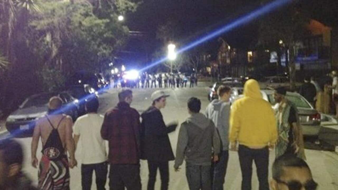 A crowd confronting police at a disturbance at a spring break party.
