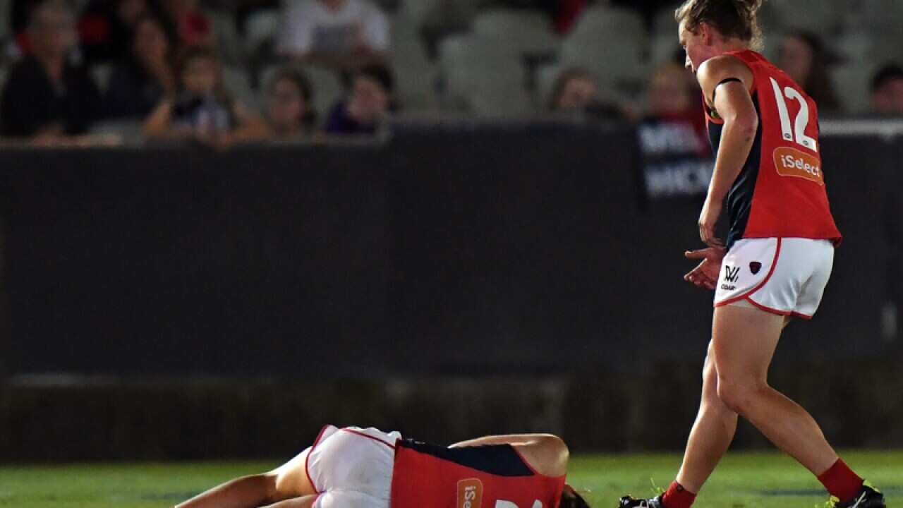 Meg Downie of Melbourne on the ground after being knocked out