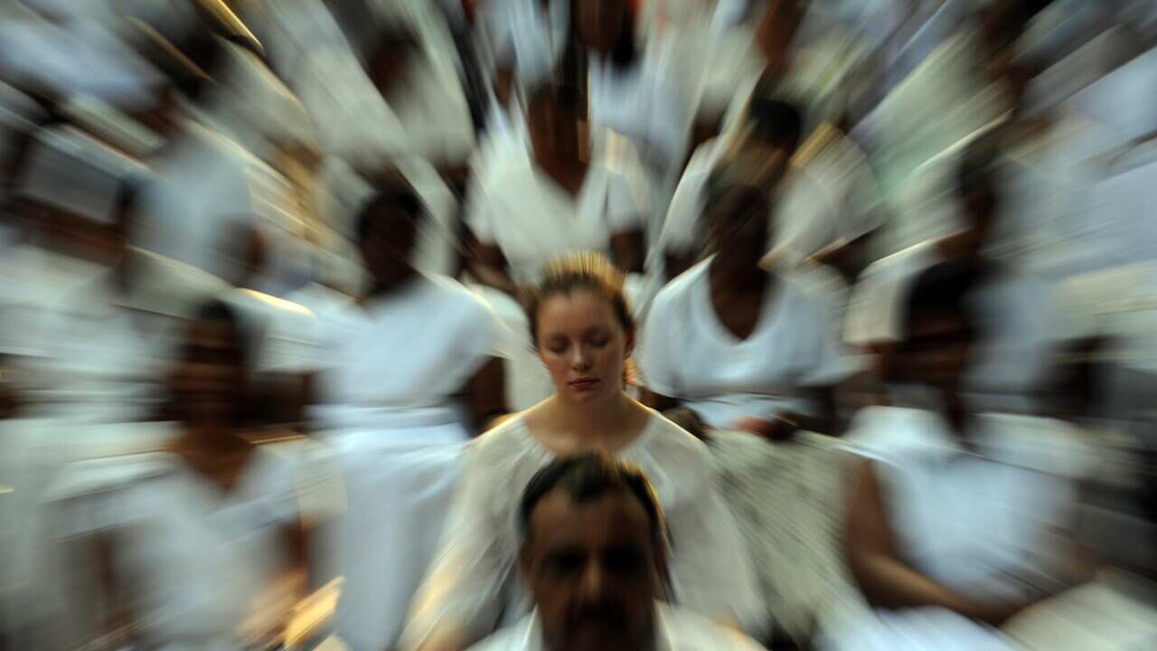 Woman in group of people meditating.