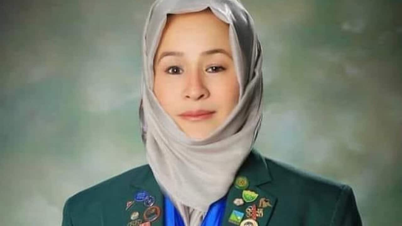 A woman with a white headscarf on a green background