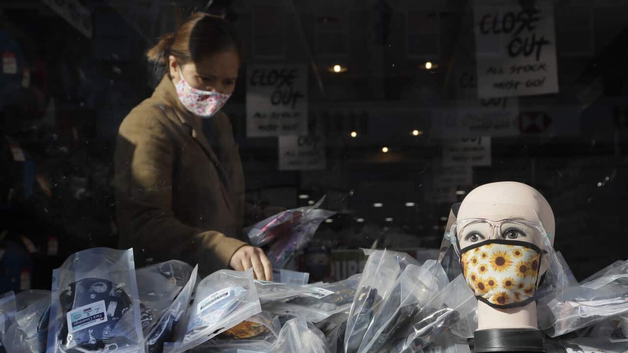 A woman looks at masks in a shop in London