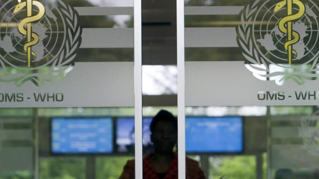 A woman approaches the entrance of the WHO in Geneva