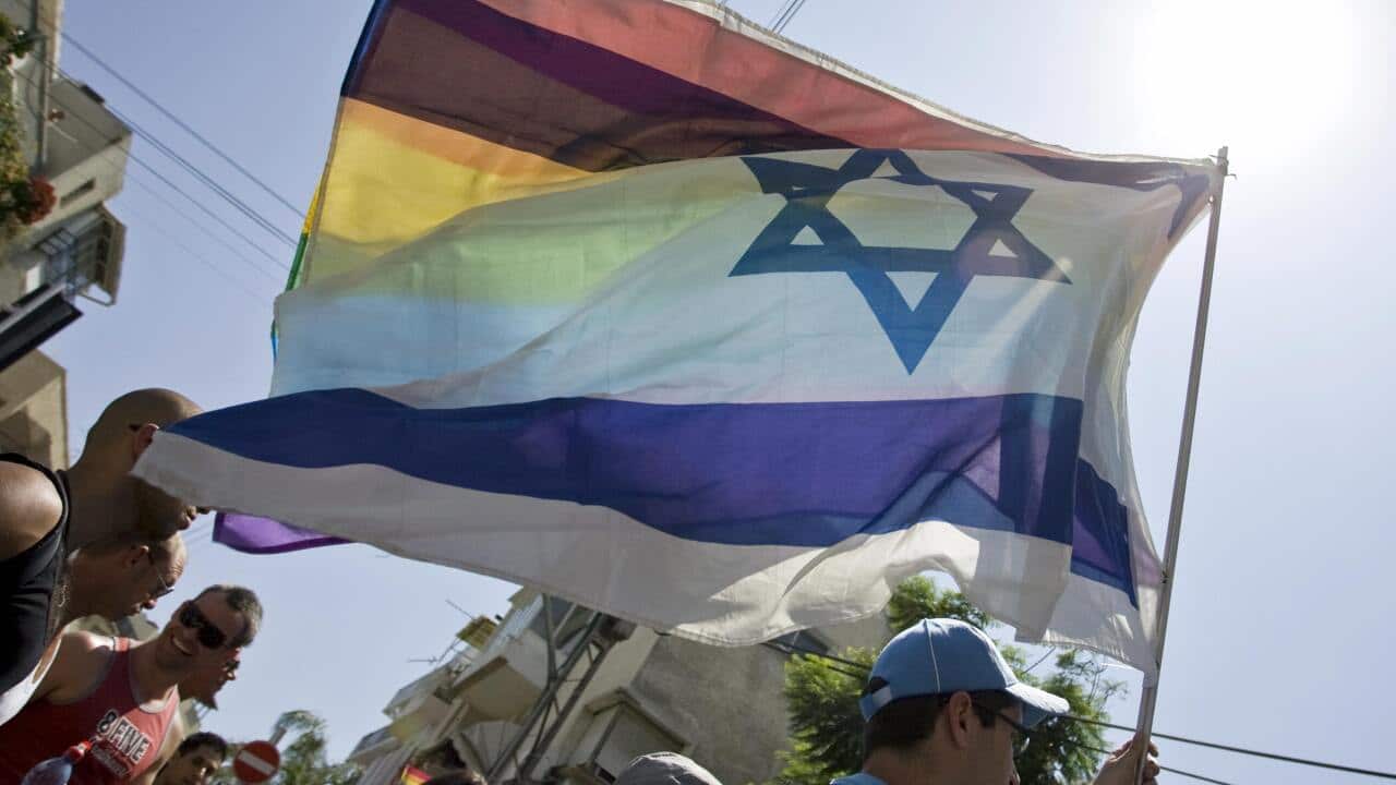 An Israeli man holds up a rainbow flag