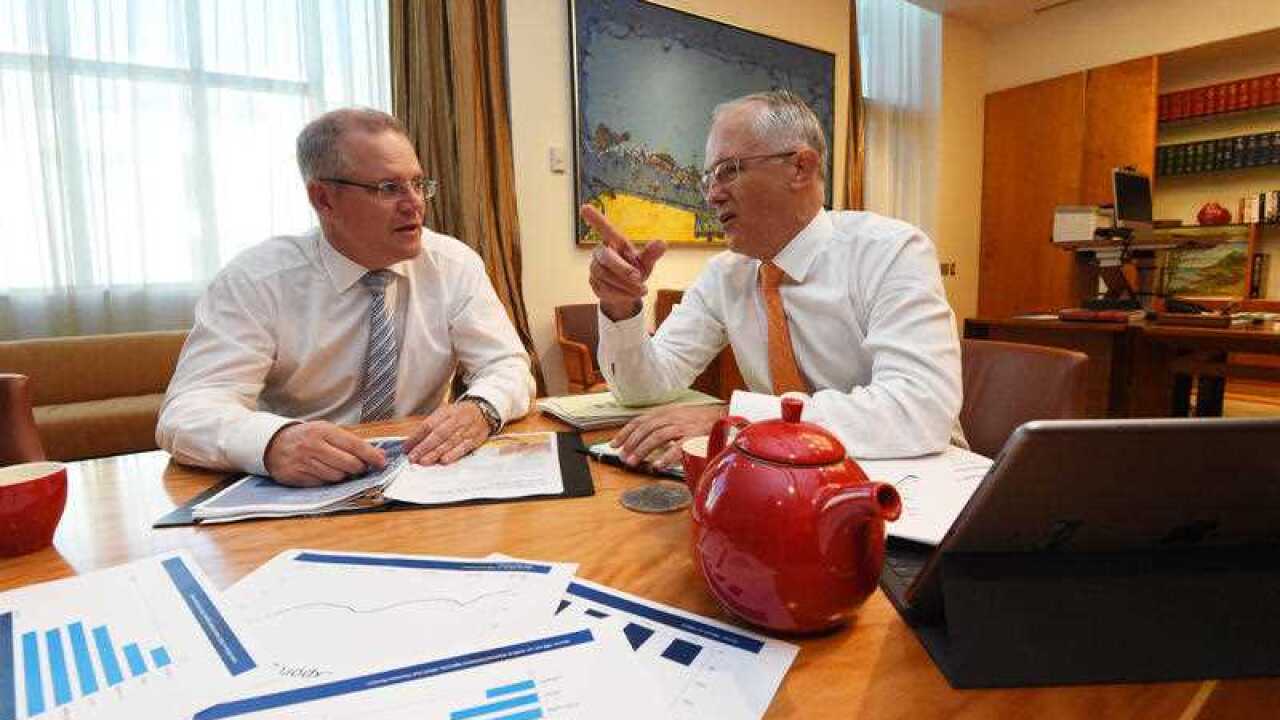 Treasurer Scott Morrison (L) and Prime Minister Malcolm Turnbull looking at the Budget Papers during a picture opportunity at Parliament House in Canberra
