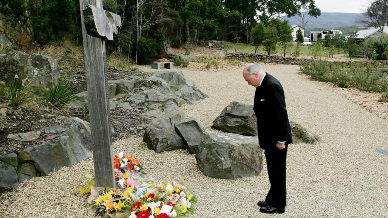 John Howard lays a wreath at a memorial.