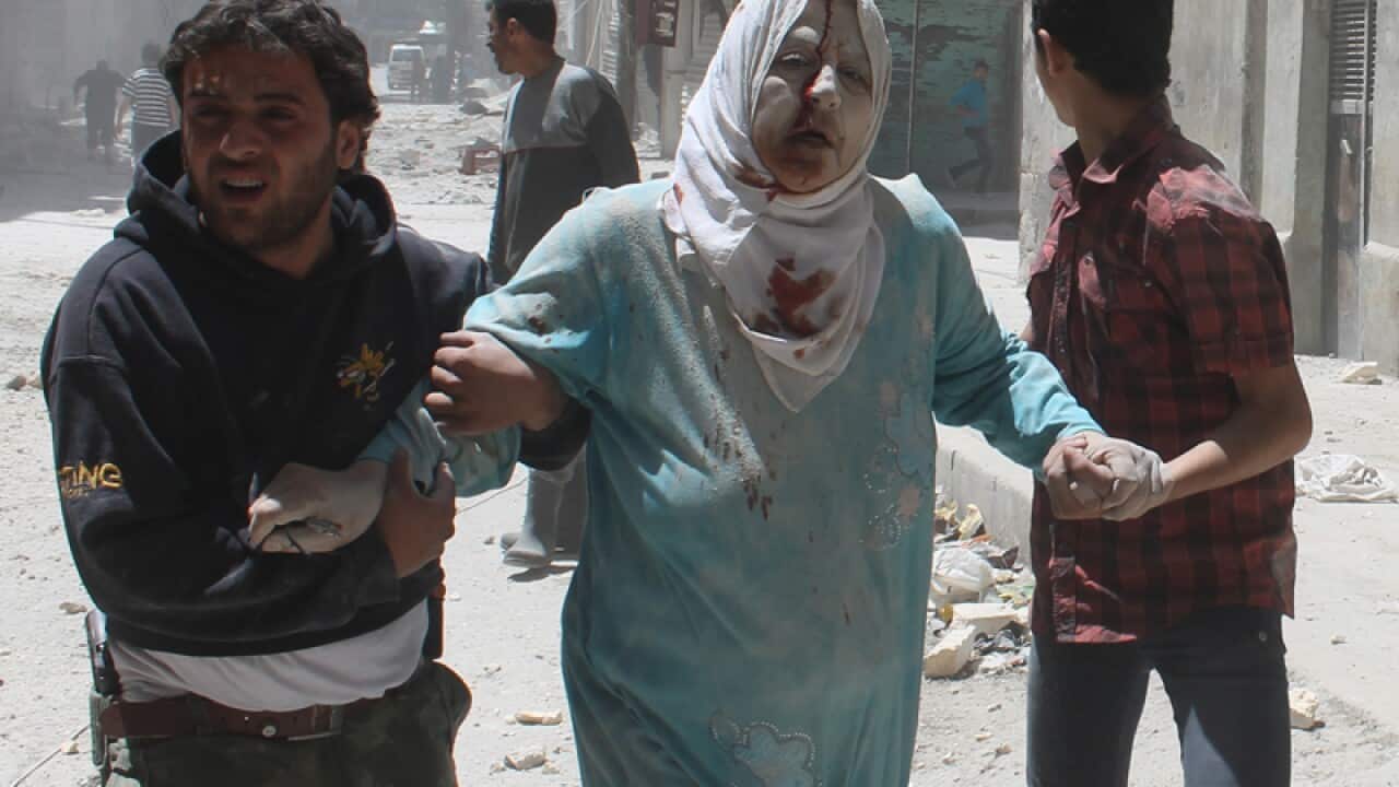 Syrian resident help an injured woman after reported air strikes