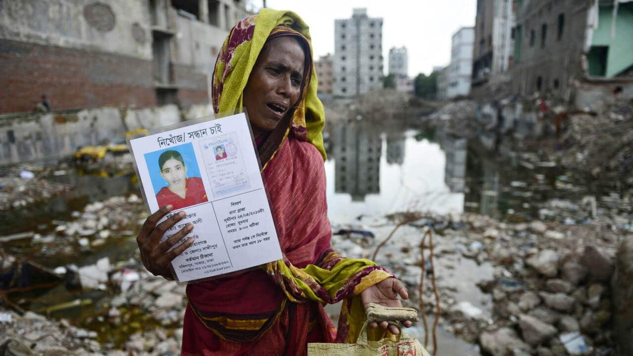 A mourner holds up a portrait of her missing relative presumed dead following the Rana Plaza garment building collapse - AAP-1.jpg