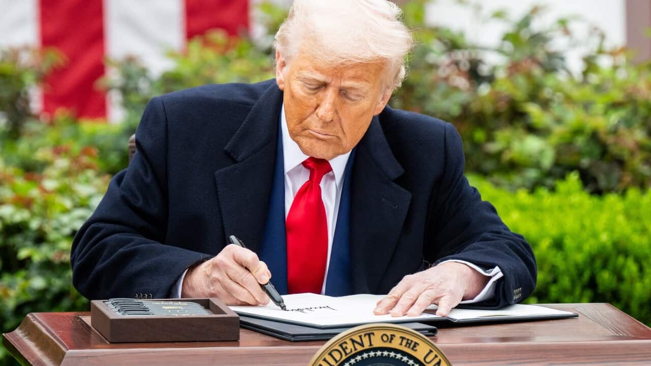 President Donald Trump signing an executive order after announcing tariffs (AAP)