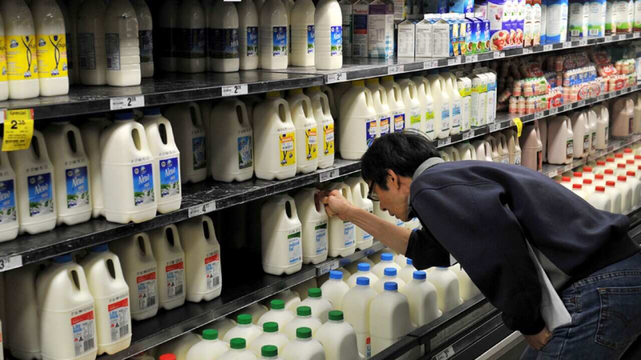 A man looks at a food product in a supermarket.