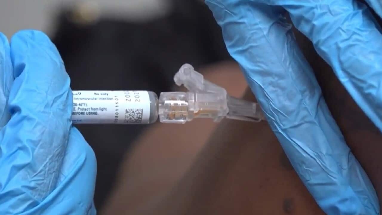 A pharmacist gives a patient a flu shot.
