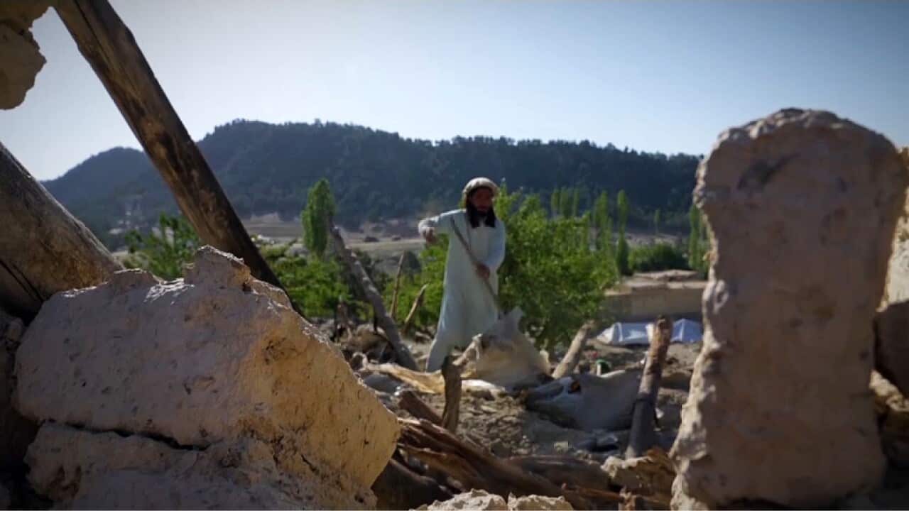 Abdul Majid sifting through the rubble of his home (AP).jpg
