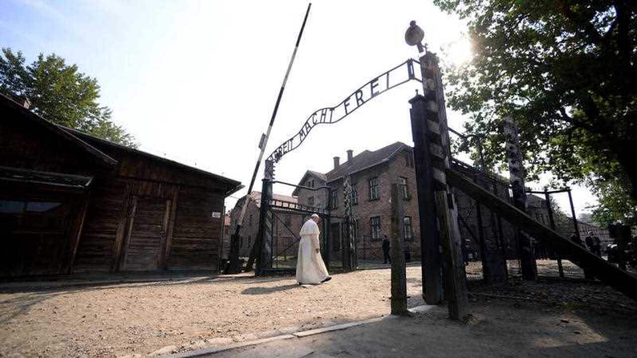 Pope Francis walks through the gate of the former Nazi German death camp of Auschwitz in Oswiecim, Poland