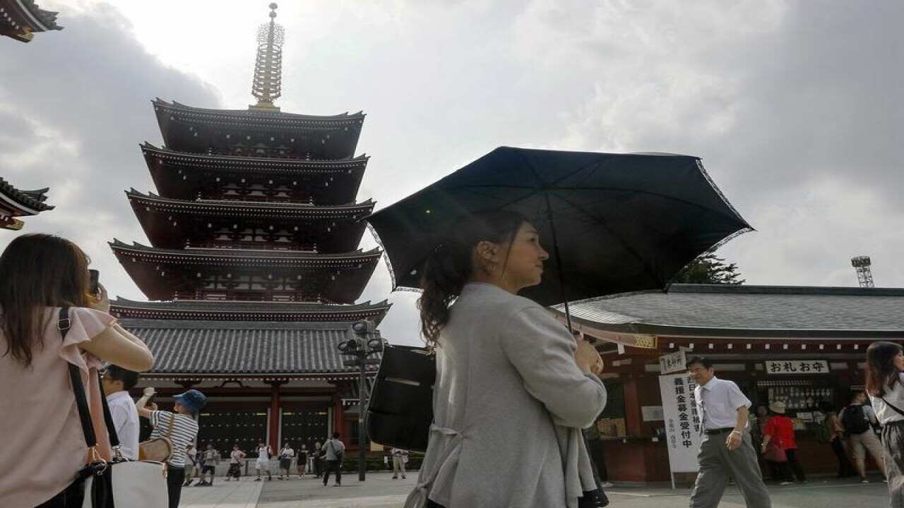 A woman uses a parasol at the Sensoji temple in Tokyo