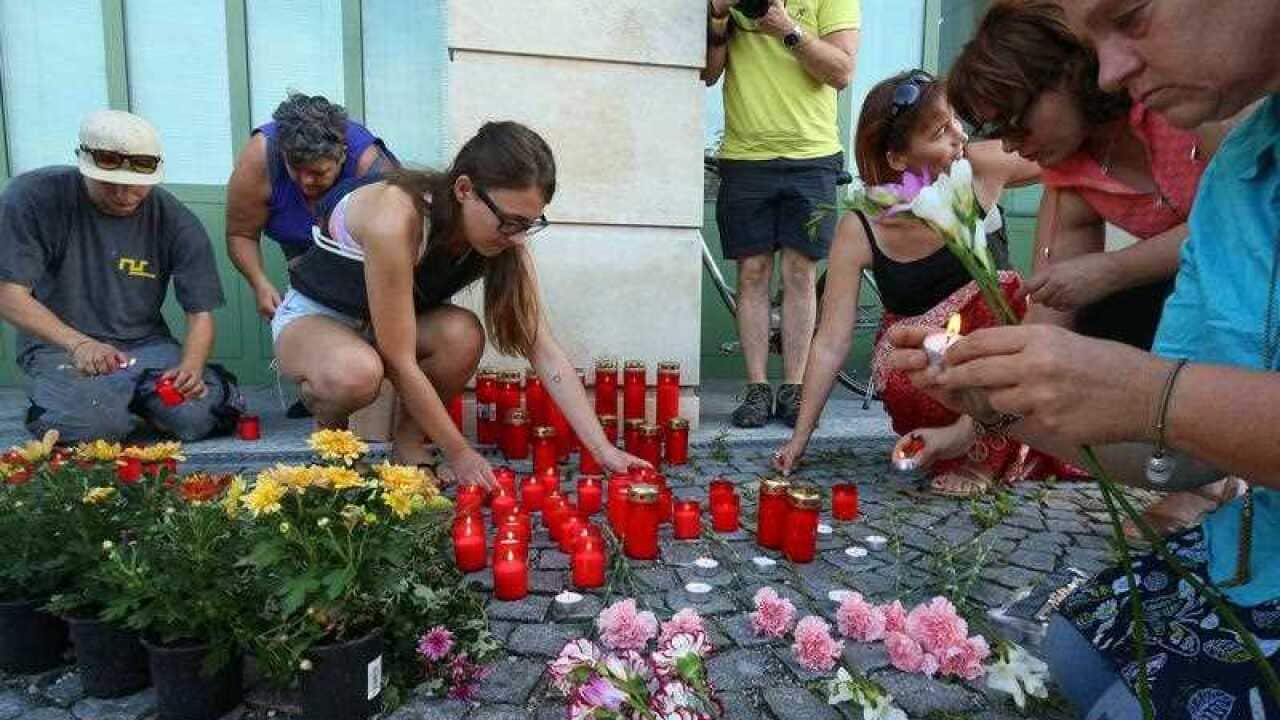 People light candles in front of the police station in Eisenstadt, Austria,
