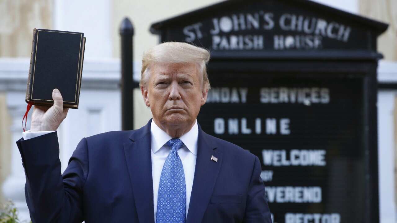 President Donald Trump holds a Bible as he visits outside St. John's Church across Lafayette Park from the White House.
