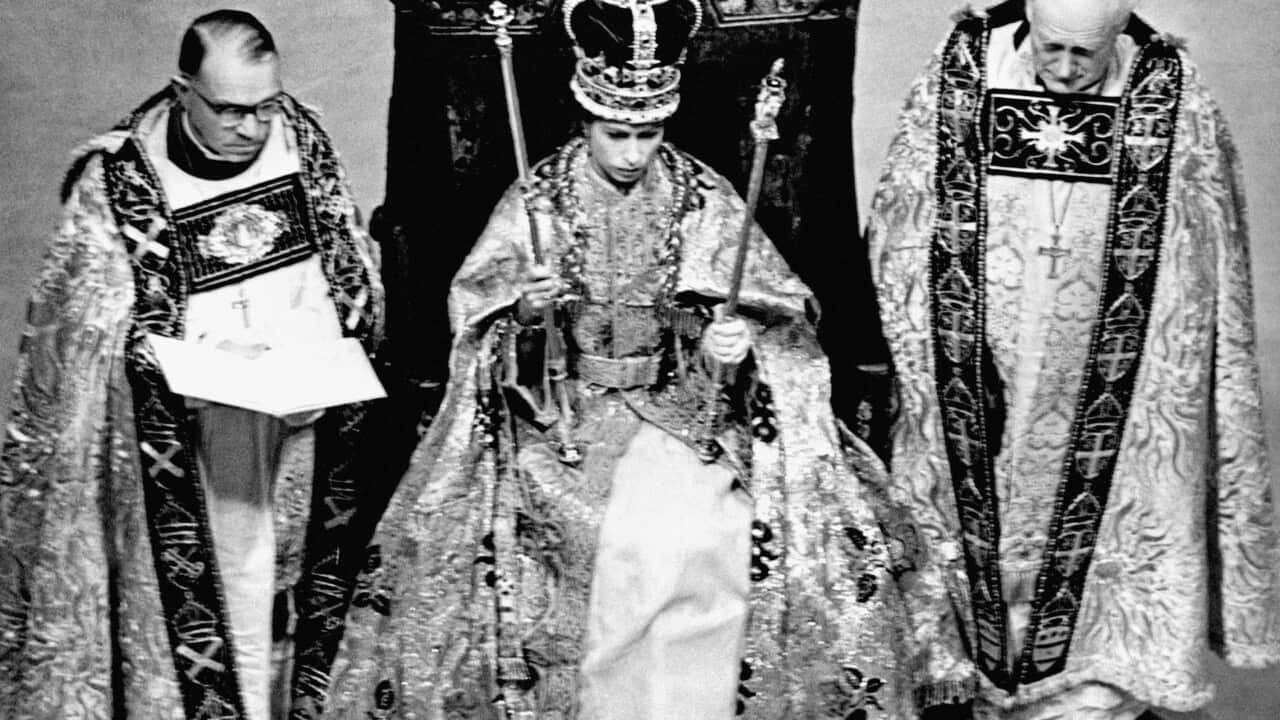 The scene after the crowning ceremony in Westminster Abbey, showing the Queen wearing the St. Edward Crown and carrying the Sceptre and the Rod.