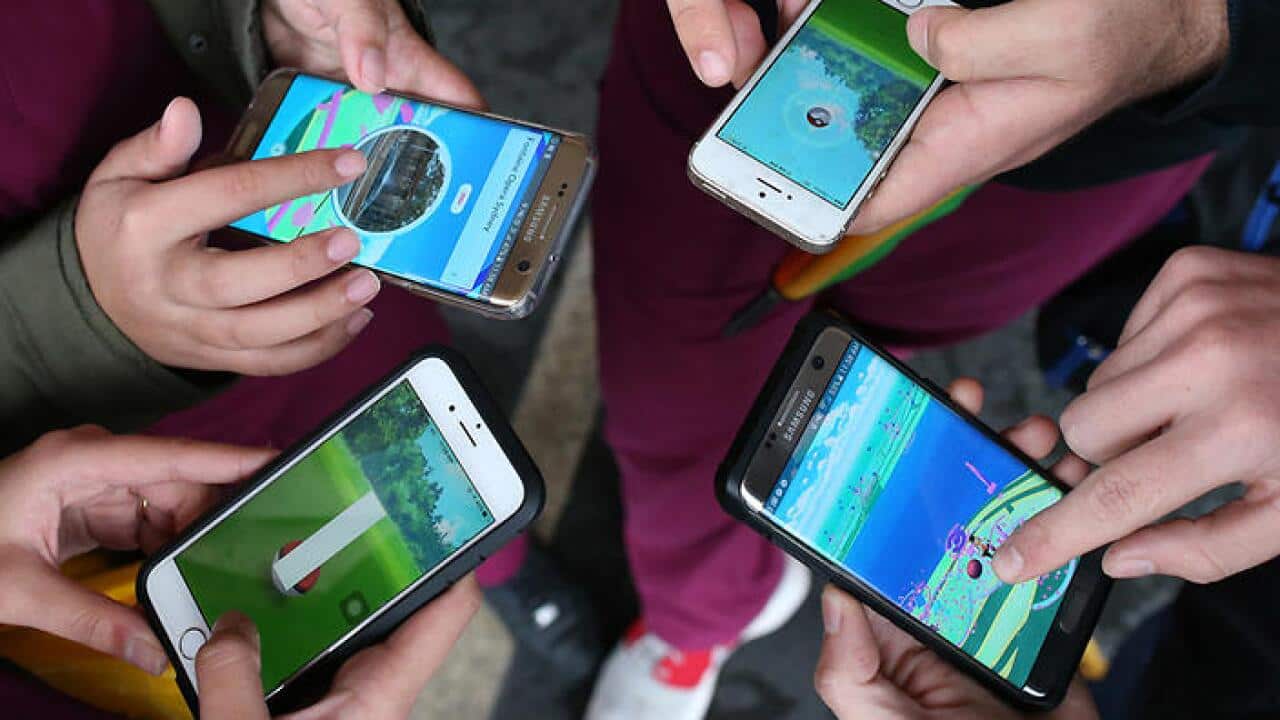 People play Pokemon Go on their mobile phones near the Sydney Opera House in Sydney, Wednesday, July 20, 2016.
