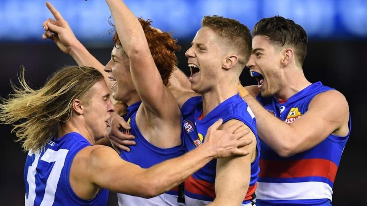 Ed Richards of the Bulldogs (second left) reacts after kicking a goal