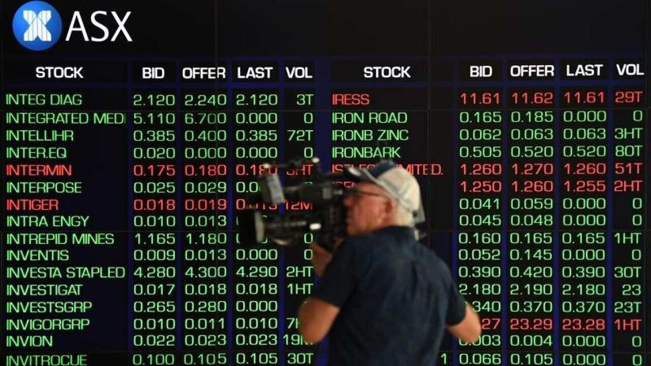 A cameraman films the market trading boards at the ASX