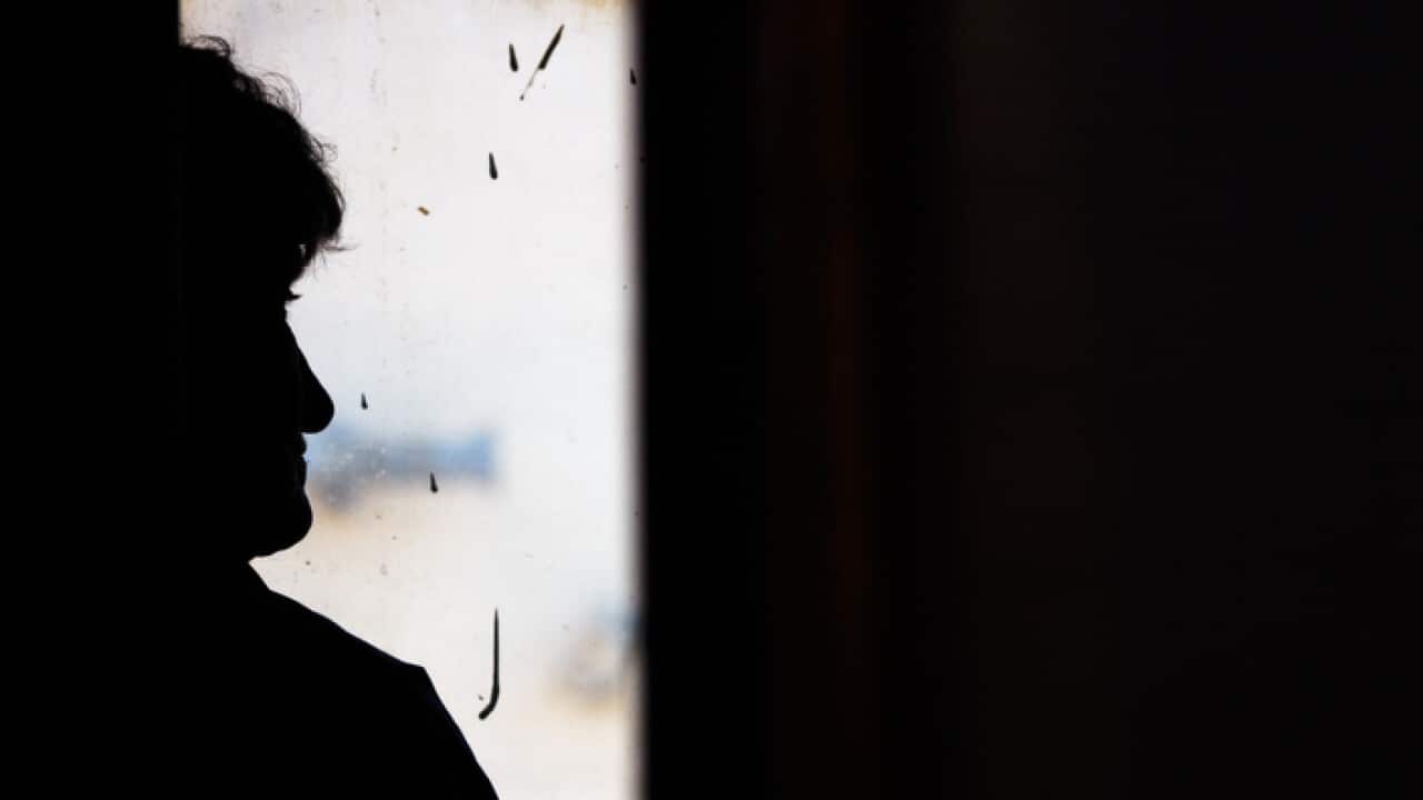 Silhouette of lone old woman in window of train. Sad emotions, nostalgia. Light and darkness