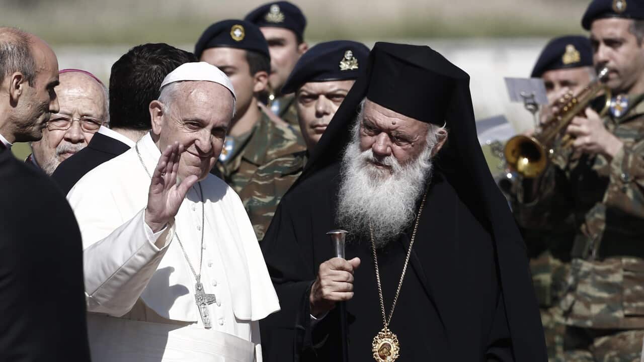 Pope Francis (L) waves to reporters as he is escorted by Greek Archbishop Ieronymos (R). (EPA)