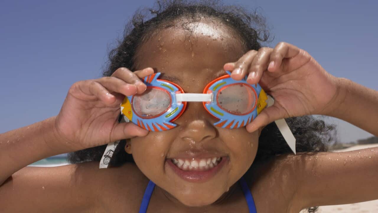Smiling girl wearing goggles at beach