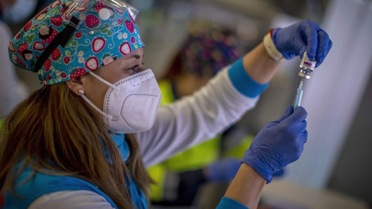 A file photo of a health worker holding a vial of AstraZeneca vaccine.