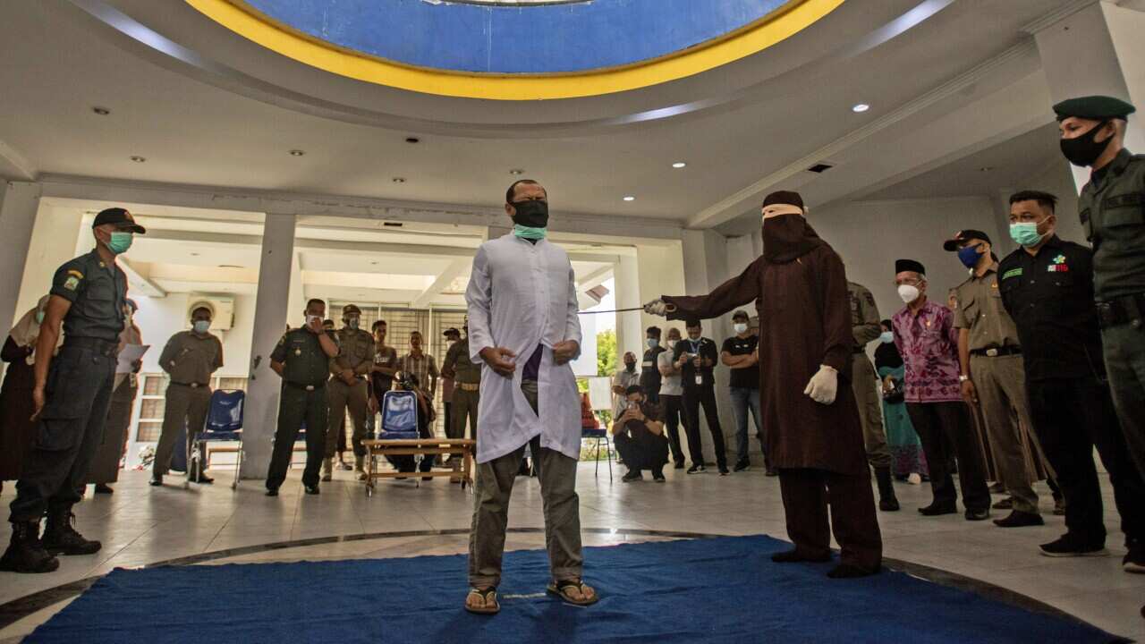 A Sharia Law official uses a rattan cane to whip one of two men convicted of gay sex in Banda Aceh, Aceh province, Indonesia, on 28 January.