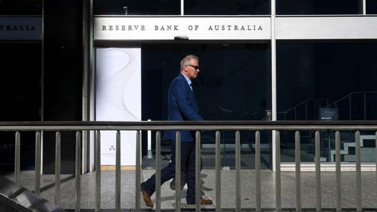 A man walks past the Reserve Bank of Australia building in Sydney