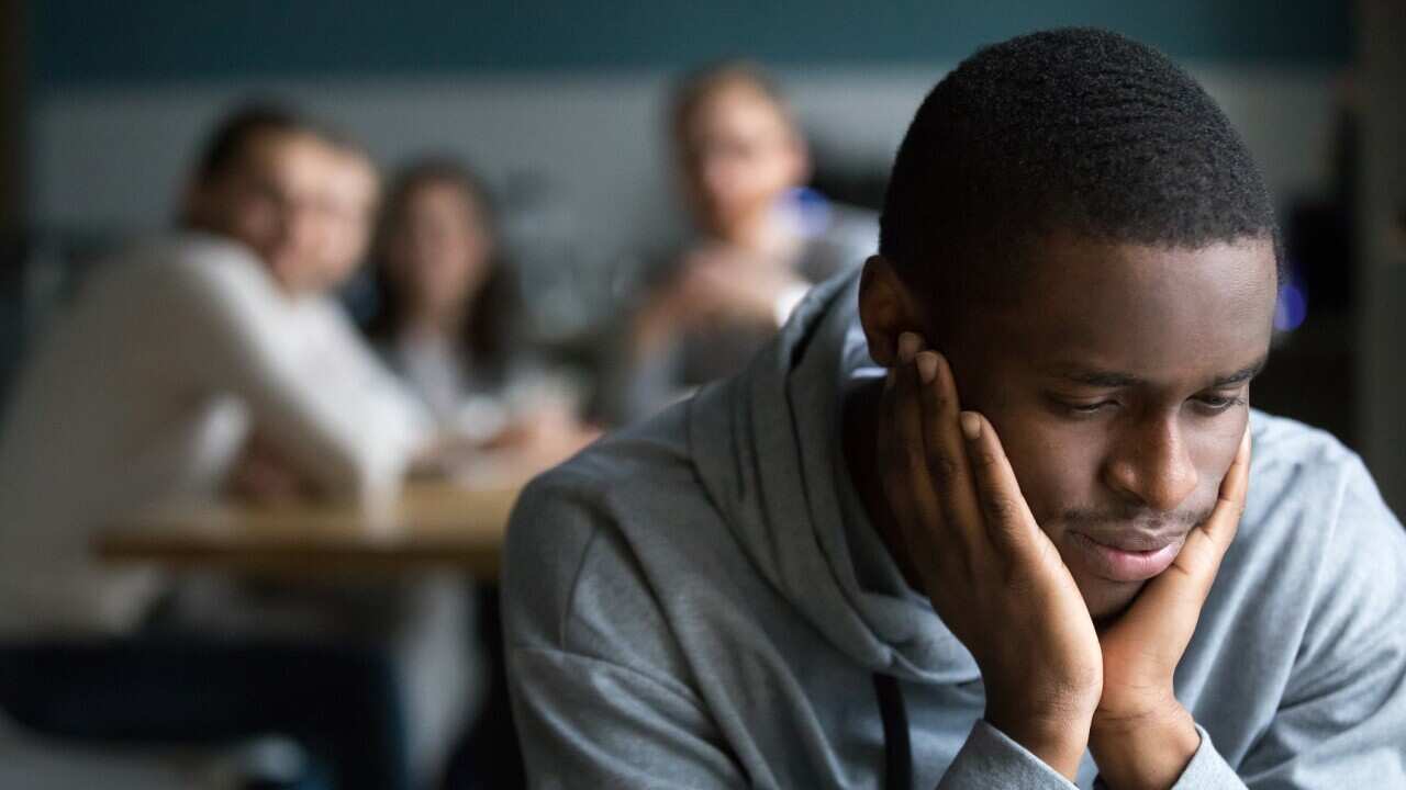 Black guy sit alone in cafe suffering from racial discrimination