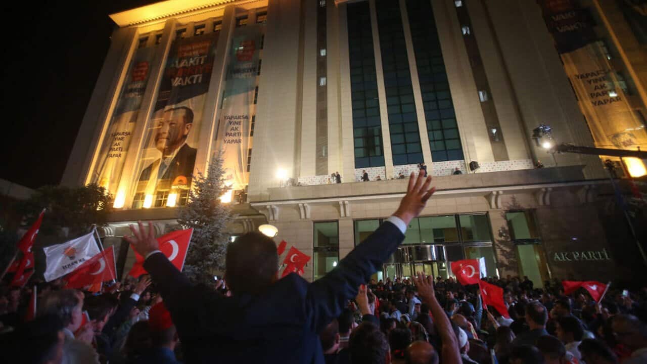 Supporters of Turkey's President Recep Tayyip Erdogan listen their leader as they gathered in front of the AK Party headquarters on June 25