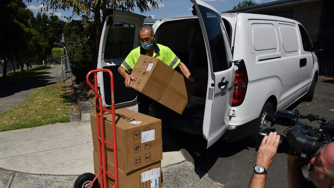 A worker delivers boxes of Rapid Antigen Tests at a primary school in Glen Waverley, Melbourne