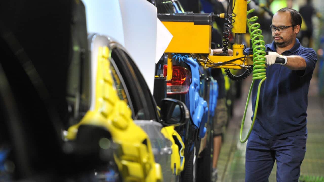 A worker on a car assembly line