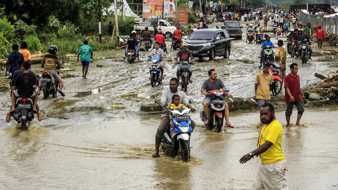 Residents ride through flood water in Sentani, near Jayapura, Papua province, Indonesia.