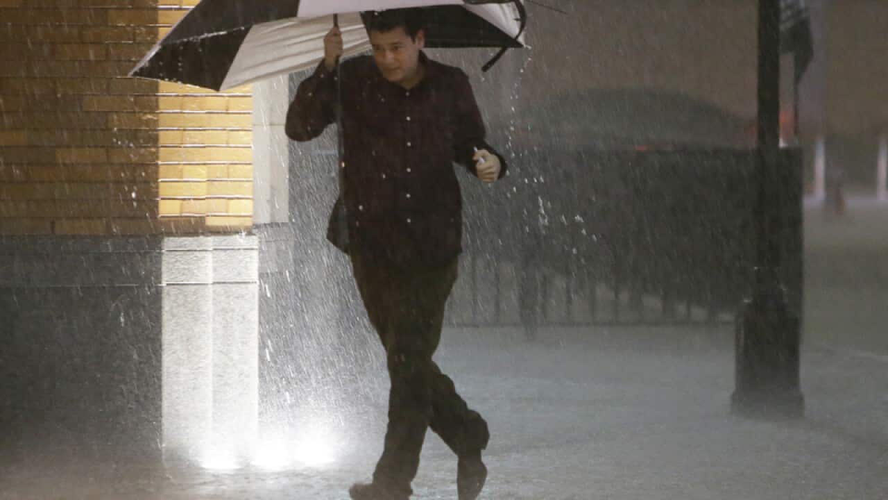 A man runs as sirens sound during a severe storm over downtown Dallas.
