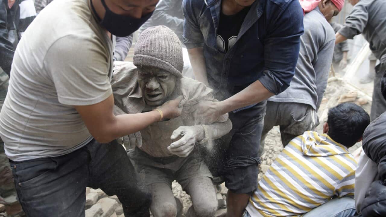 People free a man from the rubble in Kathmandu