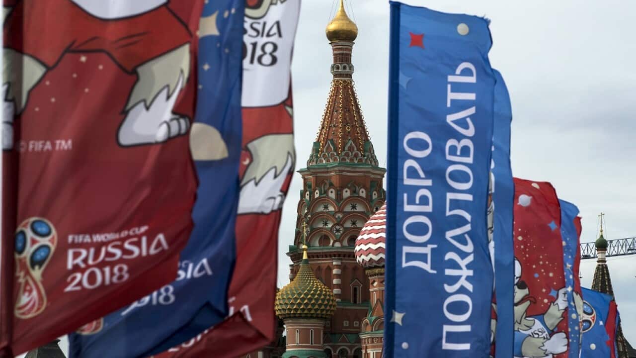 Flags with the World Cup 2018 logo on display in Moscow with the St. Basil's Cathedral in the background.
