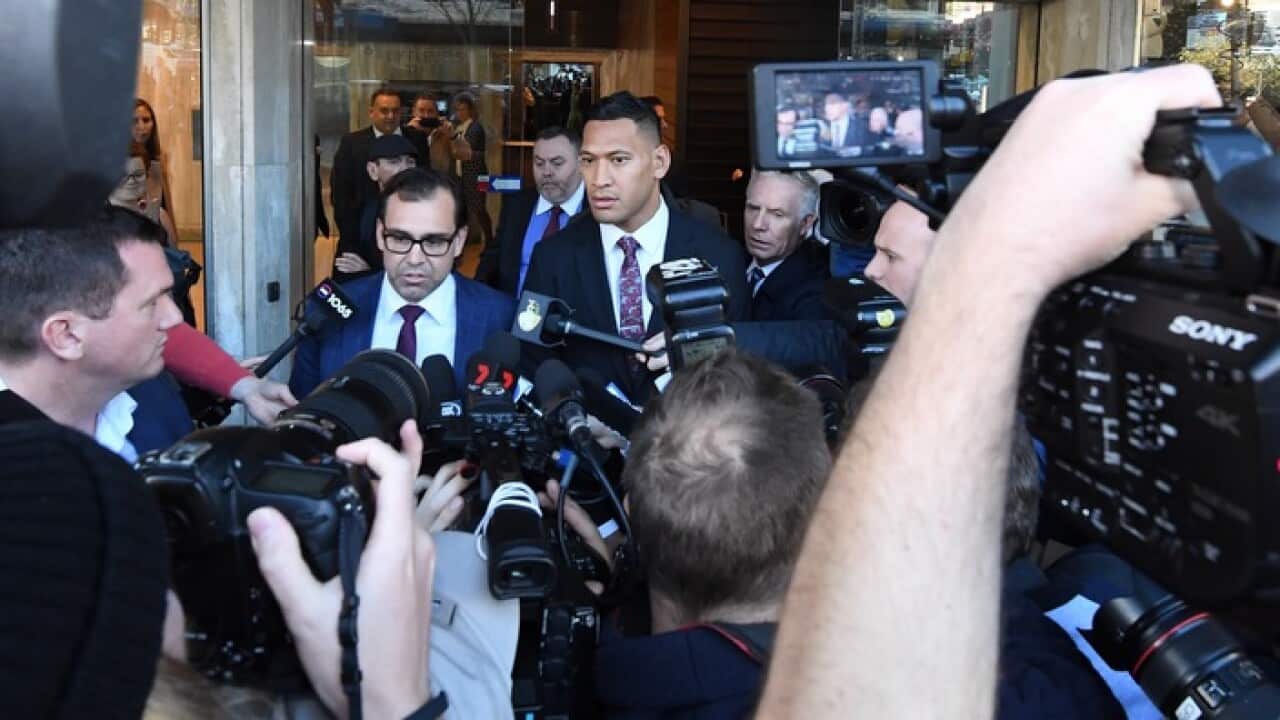 A media scrum surrounds Israel Folau after he leaves the Fairwork Commission
