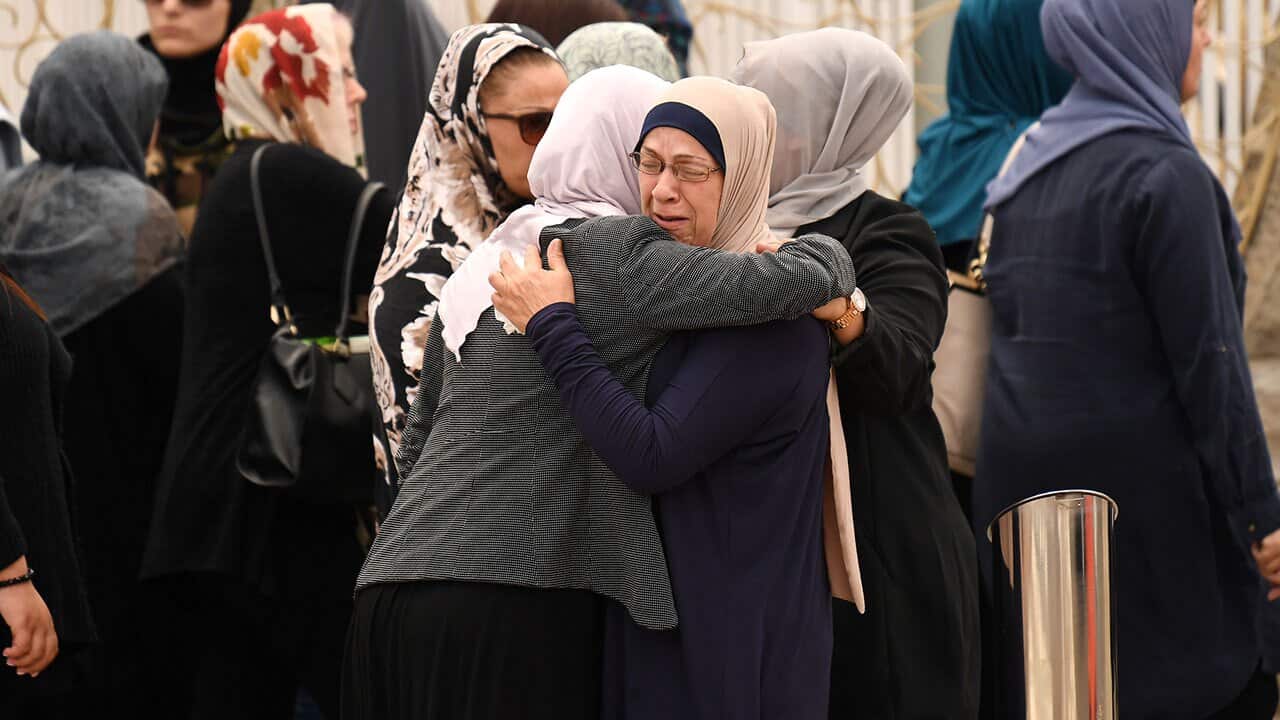 Women embrace before attending the funeral of a schoolboy killed at Banksia Road Primary School in Greenacre.