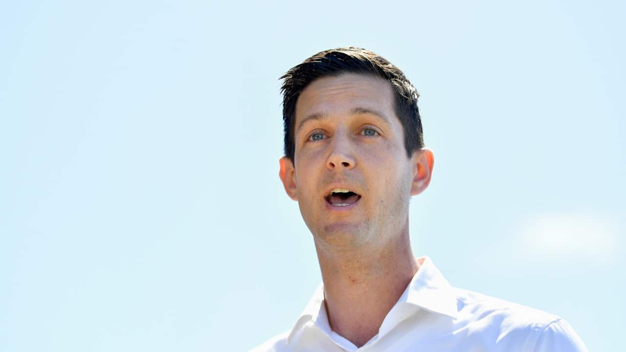 A man in a white shirt speaking outside