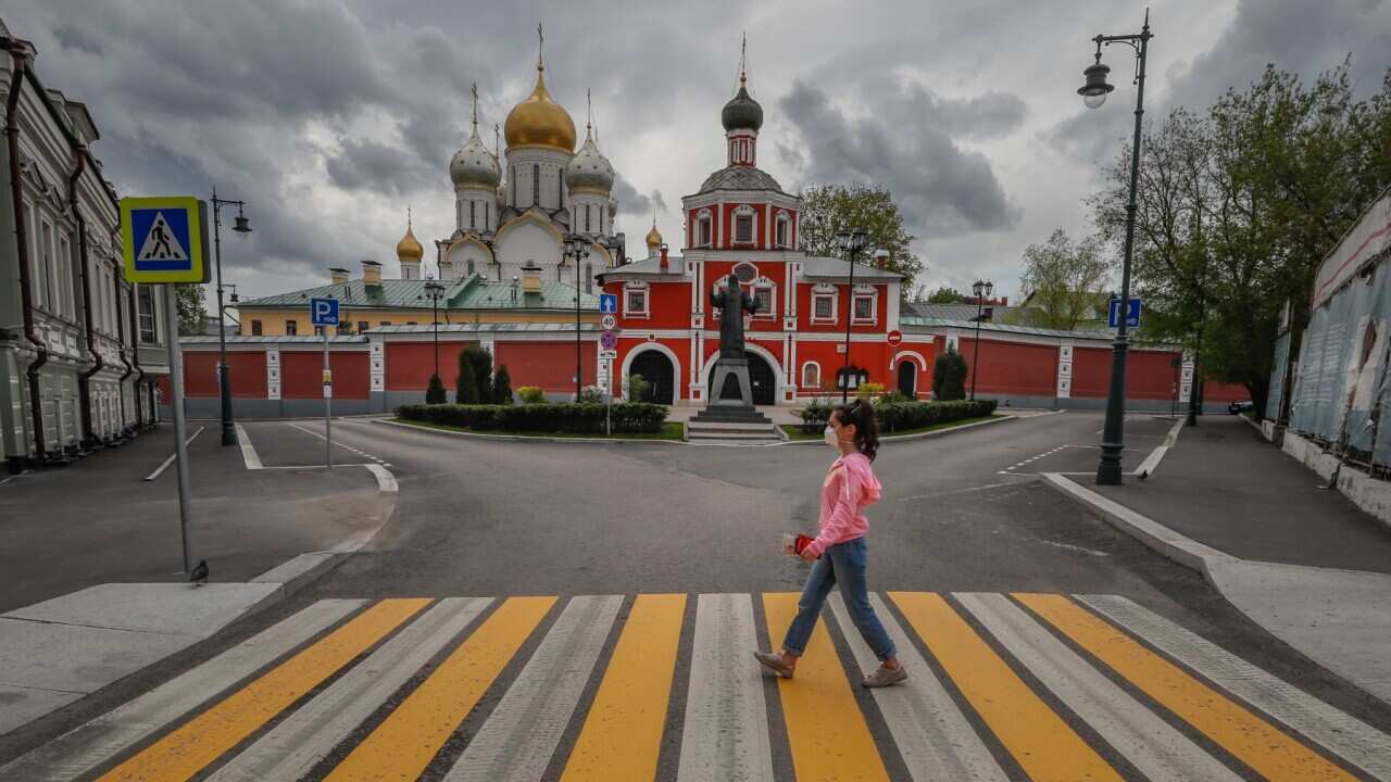A woman wearing protective mask crossing a deserted road in front of Zachatievsky Stavropegial Convent amid the ongoing coronavirus COVID-19 pandemic in Moscow, Russia, 07 May 2020. Russian President Vladimir Putin extended a home quarantine to 11 May 202