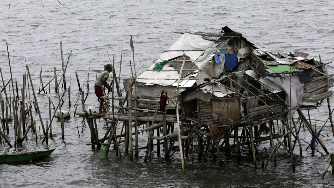A fisherman takes shelter on a shanty at a coastal village in Bacoor city, Philippines.